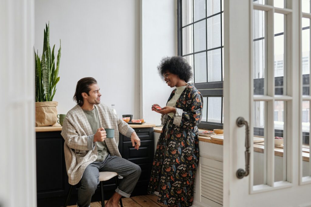A couple enjoys a casual morning chat over coffee in a stylish home interior.